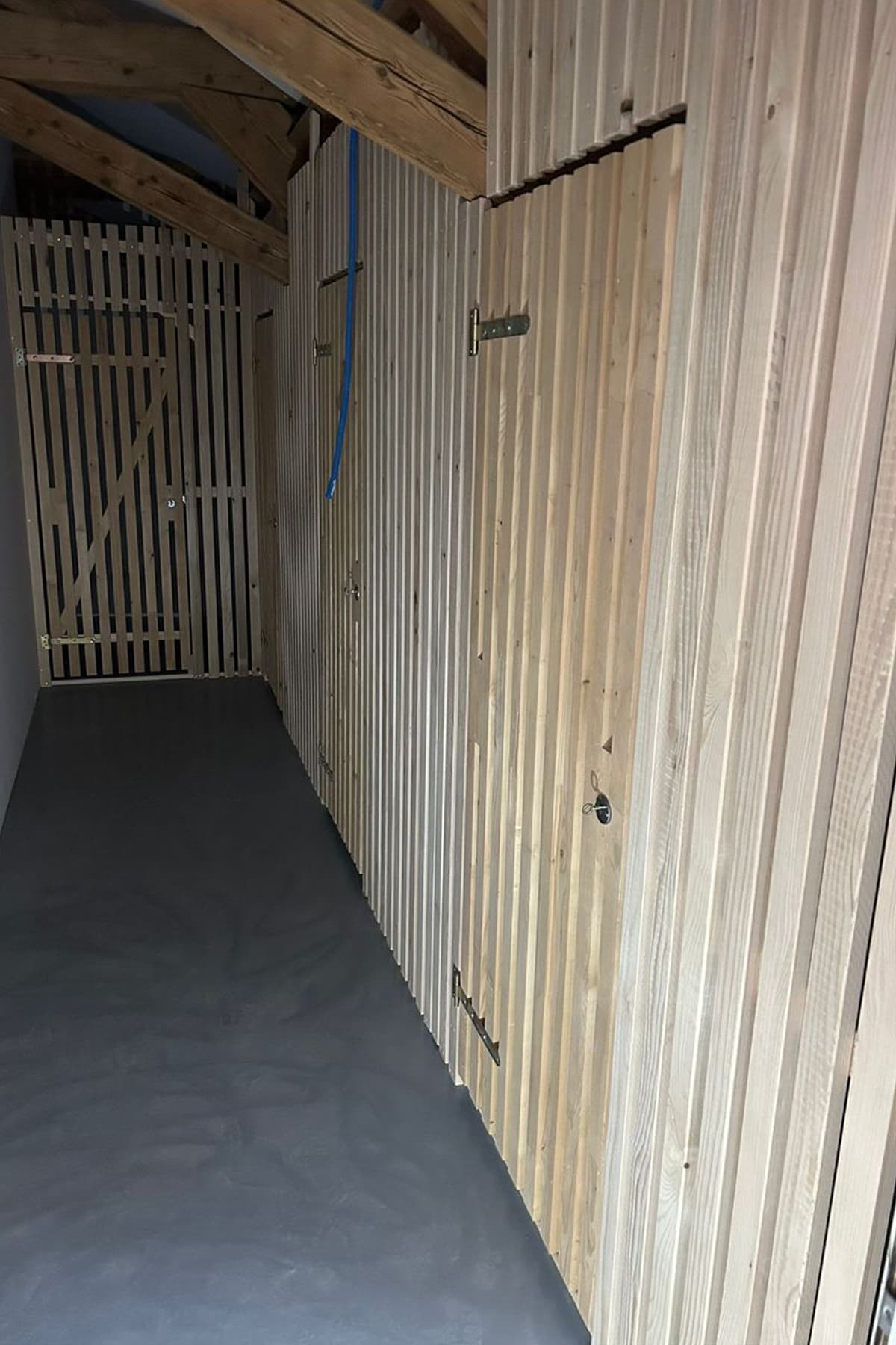 Habillage mural en lames de bois massif verticales avec porte ajourée